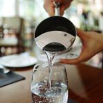 Image of pouring water from a kettle into cups on a table