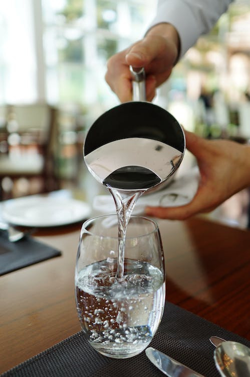 Image of pouring water from a kettle into cups on a table